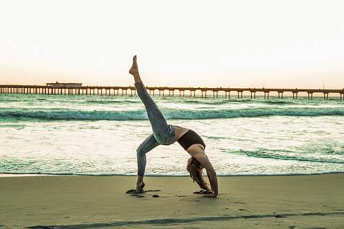 fitness woman doing yoga pose on seashore sport